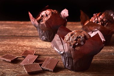 Eski ahşap masa üzerinde tatlı kakaolu keklerle dolu bir hayat.