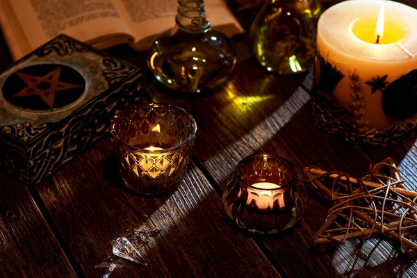 在古老的木制桌面上点着蜡烛 还有魔法书和五芒星盒 过着平静的生活 适用于魔法或深奥的东西 — 图库照片