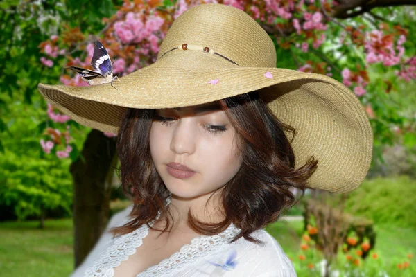 Menina bonita com borboleta em chapéu de palha — Fotografia de Stock