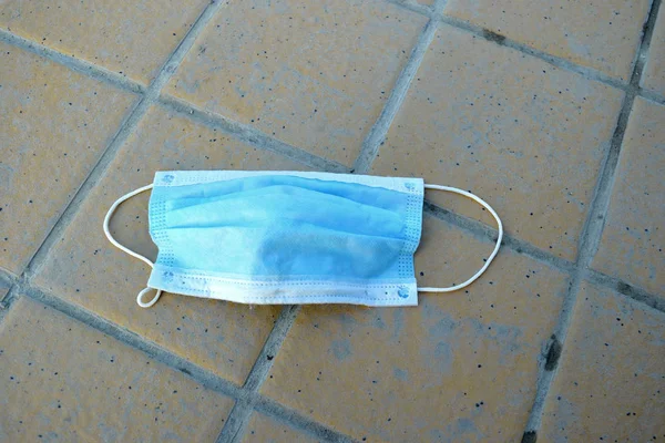 Boş caddede terk edilmiş tıbbi maske.