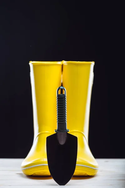 Rubber boots and garden tool — Stock Photo, Image