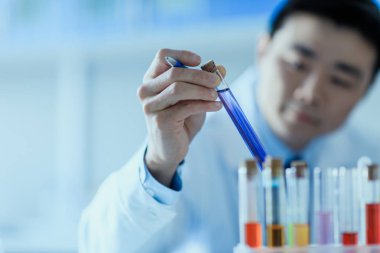Test tüpü tutan bilimadamı 