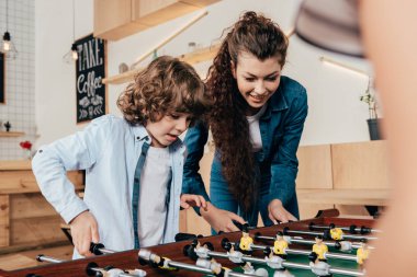 mother and son playing table footbal clipart