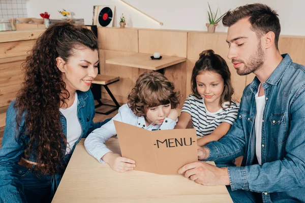 Familia con la lista de menú en la cafetería — Foto de Stock