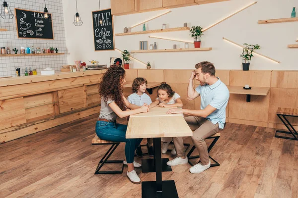 Gelukkige jonge familie in café — Stockfoto