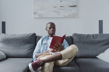 Afrikalı Amerikalı adam kitap okuyor. 