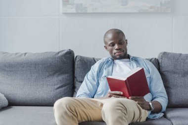 Afrikalı Amerikalı adam kitap okuyor. 