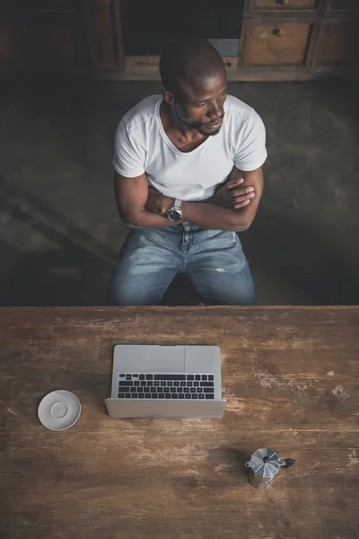 Αφρικανική αμερικανική άνθρωπος με το laptop στο τραπέζι — Φωτογραφία Αρχείου
