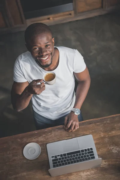 African american with coffee and laptop — Stock Photo, Image