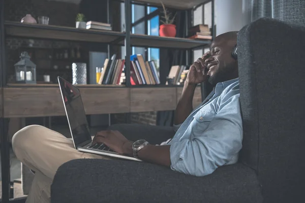 Hombre afroamericano usando el ordenador portátil en casa — Foto de Stock