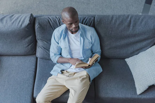 Afrikansk amerikansk man läser bok — Stockfoto