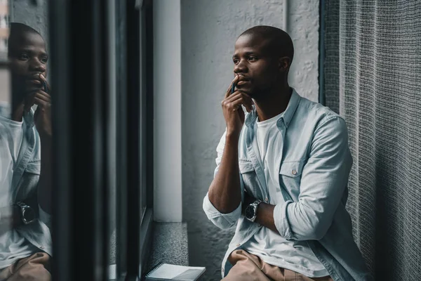 Homem americano africano olhando para a janela — Fotografia de Stock