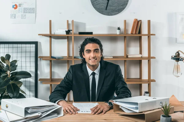 Homem de negócios sorridente no local de trabalho no escritório — Fotografia de Stock