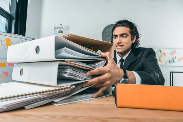 Empresário fazendo papelada no local de trabalho — Fotografia de Stock