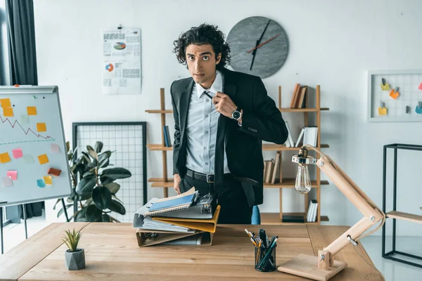 Homem de negócios amarrando gravata no local de trabalho — Fotografia de Stock