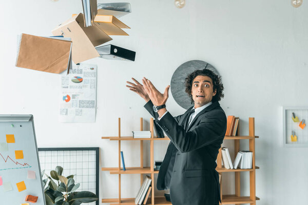 businessman throwing folders in office