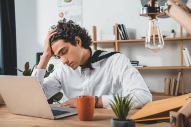 İşyerinde laptop ile oturan işadamı