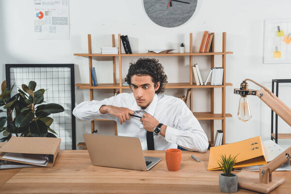 businessman sitting at workplace with laptop