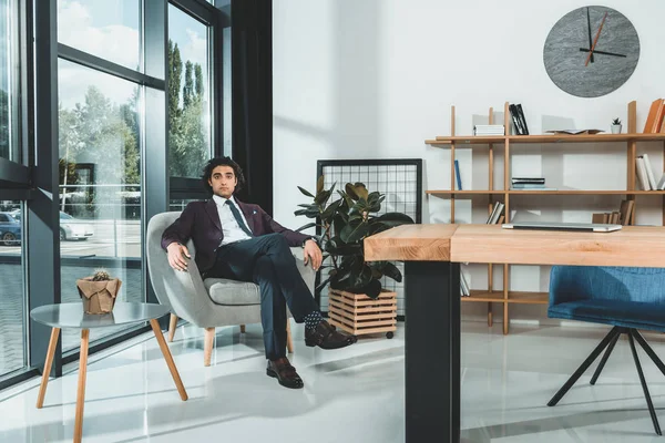 Biznesmen, siedząc w fotelu w biurze — Darmowe zdjęcie stockowe
