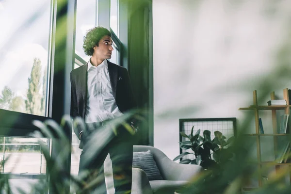 Hombre de negocios de pie en la ventana en la oficina — Foto de Stock