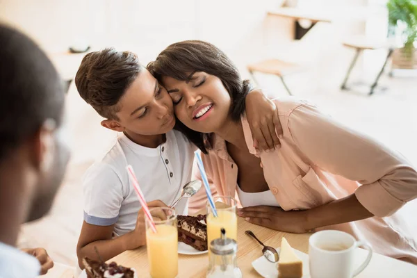 Son embracing mother in cafe — Stock Photo, Image