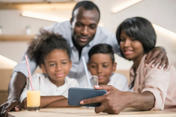 Família afro-americana olhando para o telefone — Fotografia de Stock
