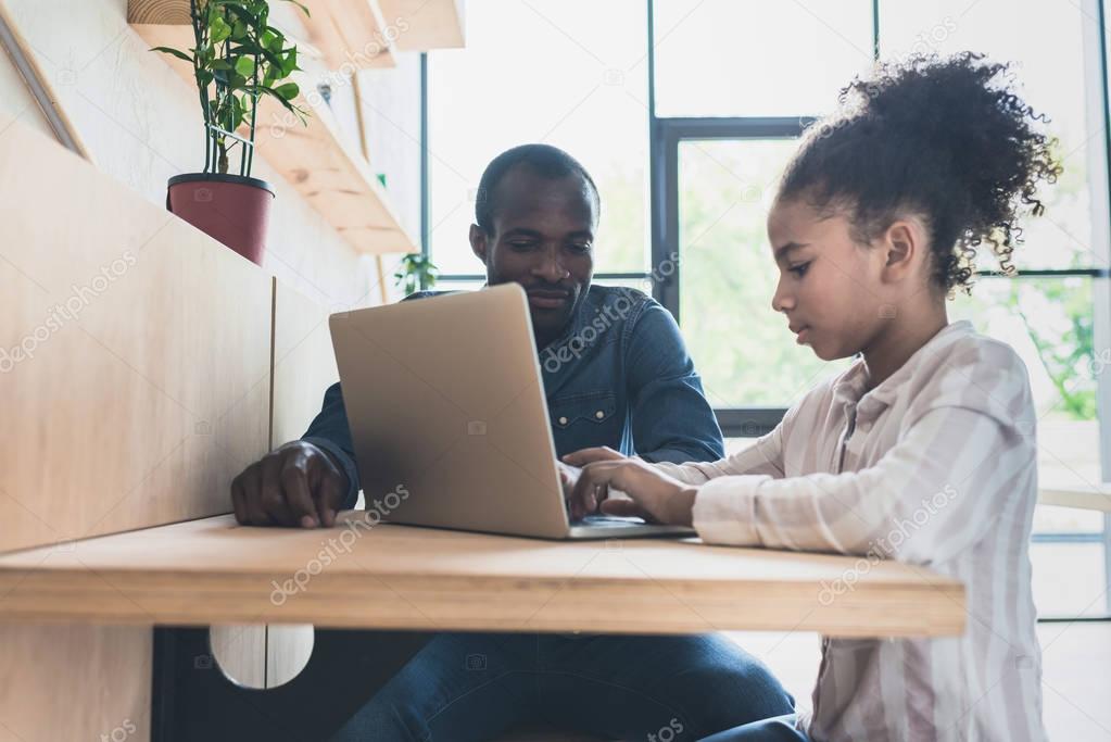 father and daughter with laptop