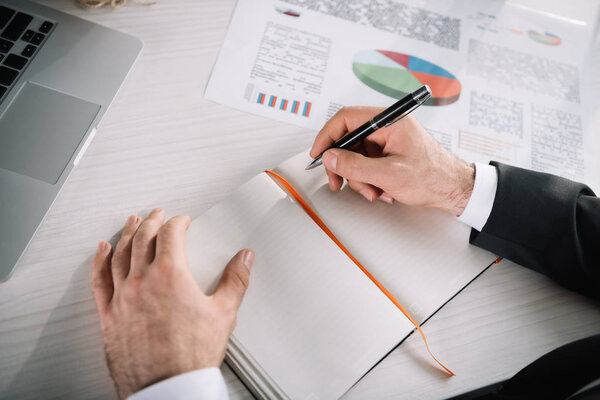 бизнесмен пишет в тетрадке