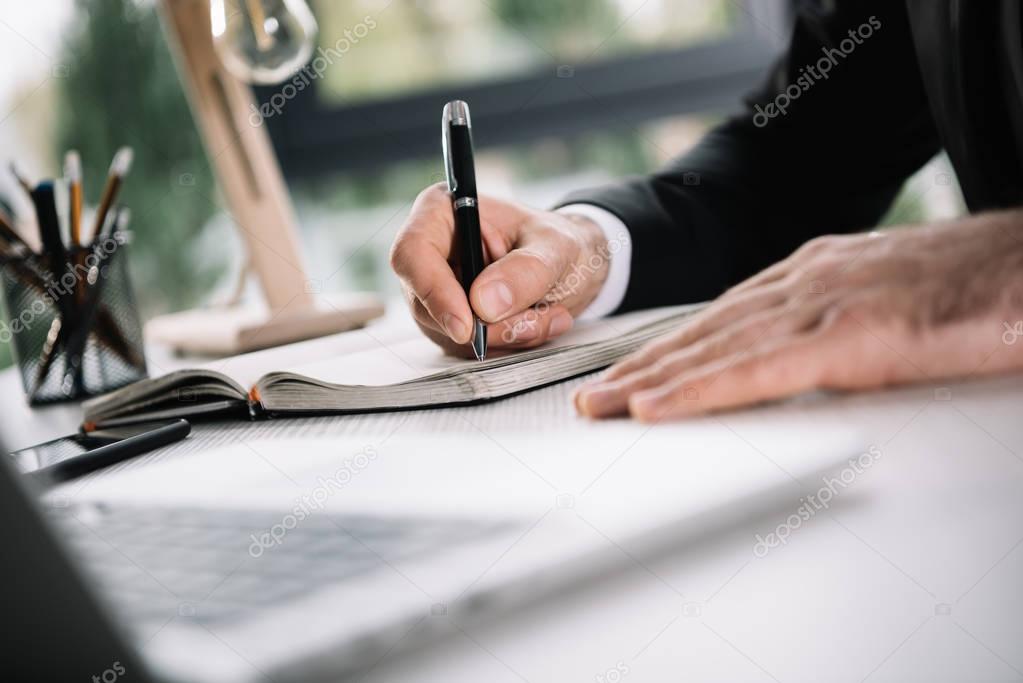 businessman writing in notebook