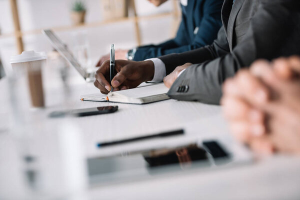 руки бизнесменов на столе
