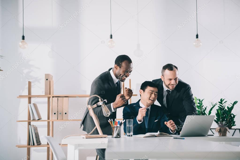 businessmen looking at laptop screen