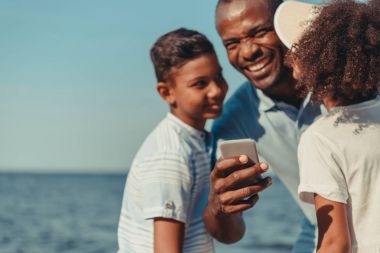 Baba ve çocuklar smartphone kullanarak