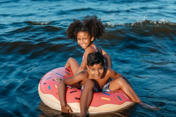 African american siblings on swimming tube — Stock Photo, Image