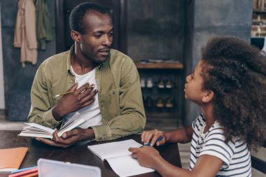 Father helping daughter do homework  clipart