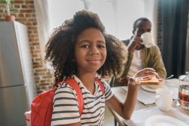 Reçelli ekmek yiyen küçük kız