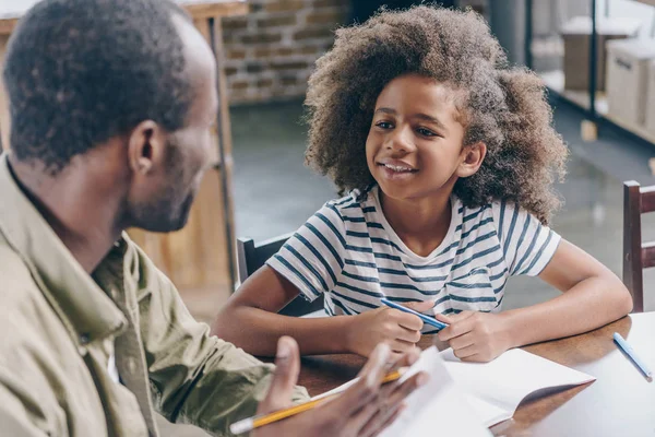 Girl talking to father at kitchen table — Stock Photo, Image