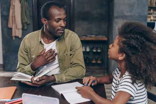 Padre ayudando a hija a hacer la tarea — Foto de Stock