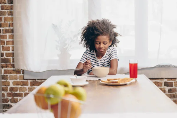 Pikkutyttö syö aamiaista — kuvapankkivalokuva