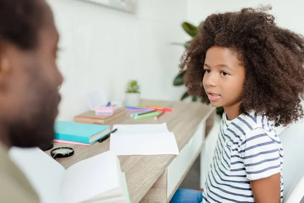 küçük kız için ders kitabı açıklayan baba