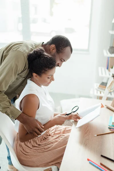 Husband hugging woman reading book — Stock Photo, Image