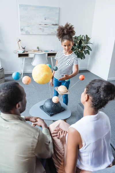 Chica diciendo a los padres sobre el sistema solar — Foto de Stock