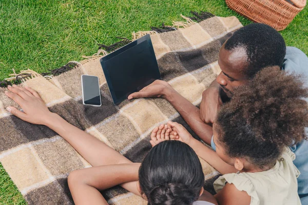 Семья с планшетом на пикнике — стоковое фото