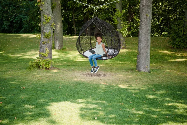 Kid swinging on swing in park — Stock Photo, Image
