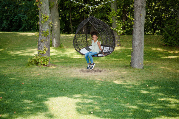 kid swinging on swing in park