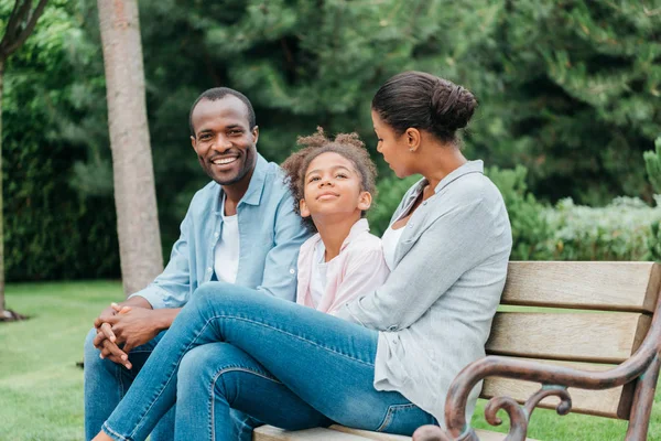 Família afro-americana descansando no banco — Fotografia de Stock