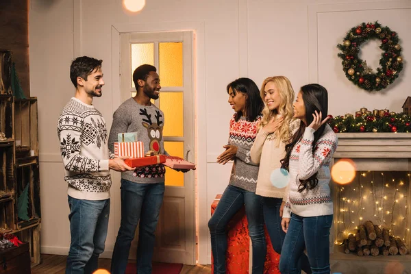 Multicultural friends exchanging christmas gifts