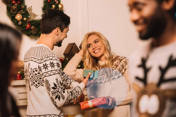 Pareja multiétnica intercambiando regalos de Navidad — Foto de Stock