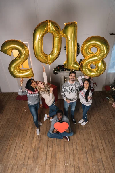 Mångkulturella vänner med ballonger och papper hjärta — Stockfoto