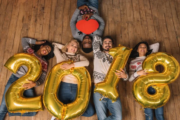 Multiculturele vrienden met ballonnen en papier hart — Stockfoto