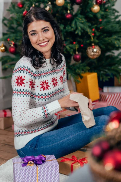 Vrouw uitpakken kerstcadeau — Stockfoto